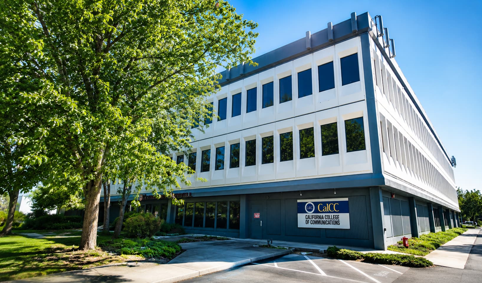California College of Communications の校舎外観。緑豊かなキャンパス環境に建つモダンな3階建ての教育施設。