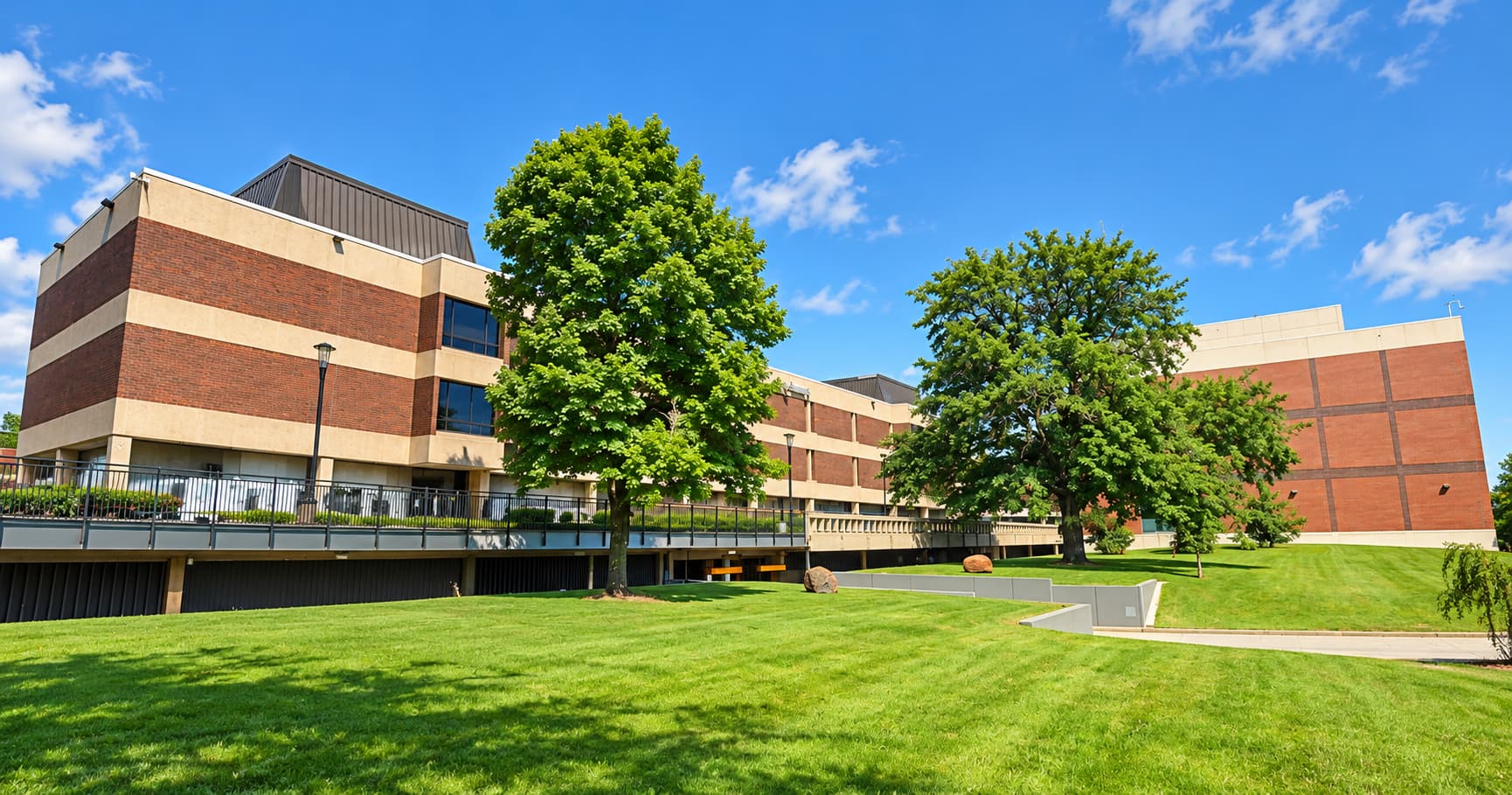青空の下、緑の芝生と木々に囲まれた Cuyahoga Community College(カヤホガコミュニティカレッジ)の校舎