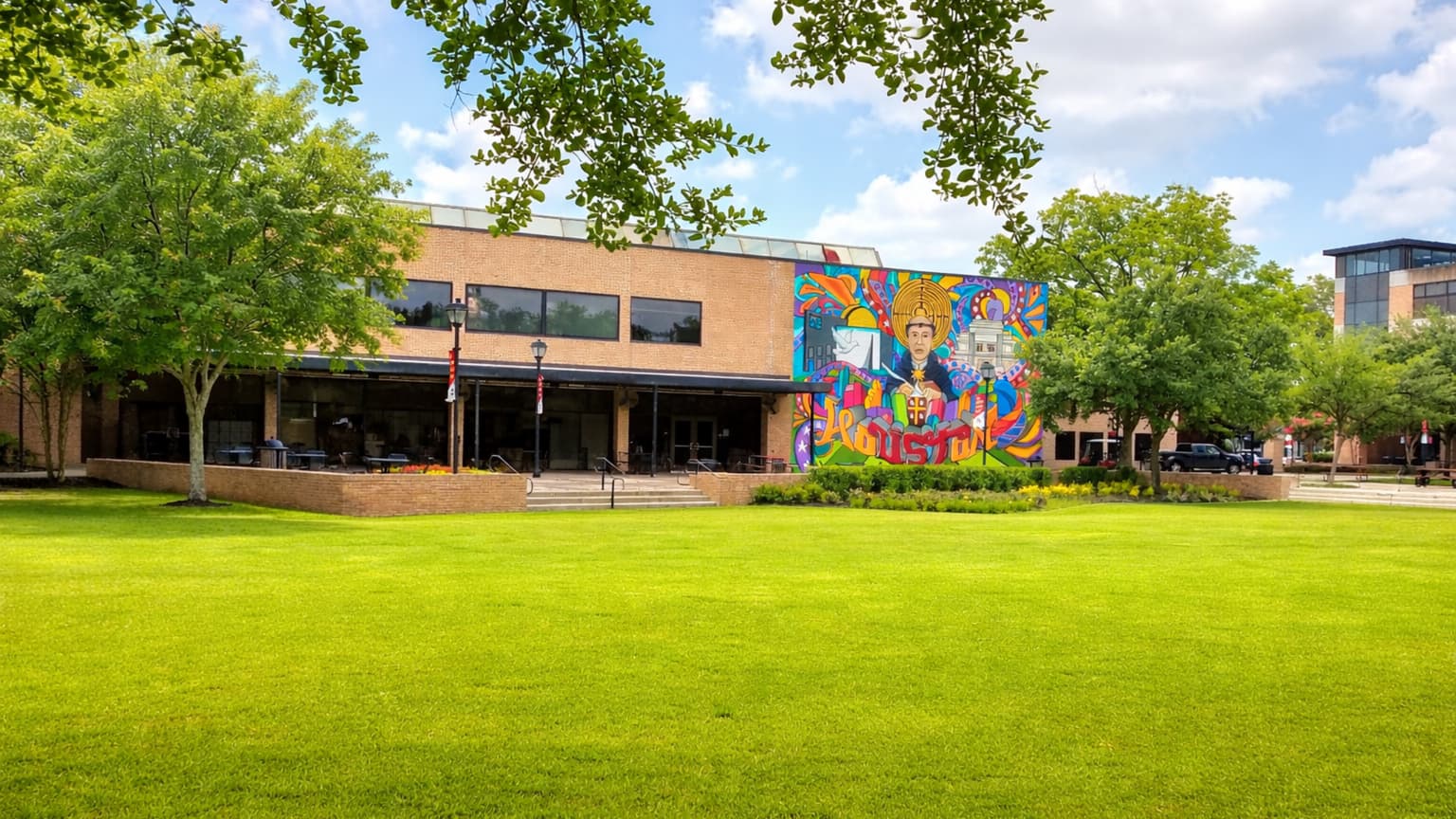 ELS Houston をイメージしたヒューストンの大学キャンパスと芝生広場、カラフルな壁画が印象的な校舎の風景