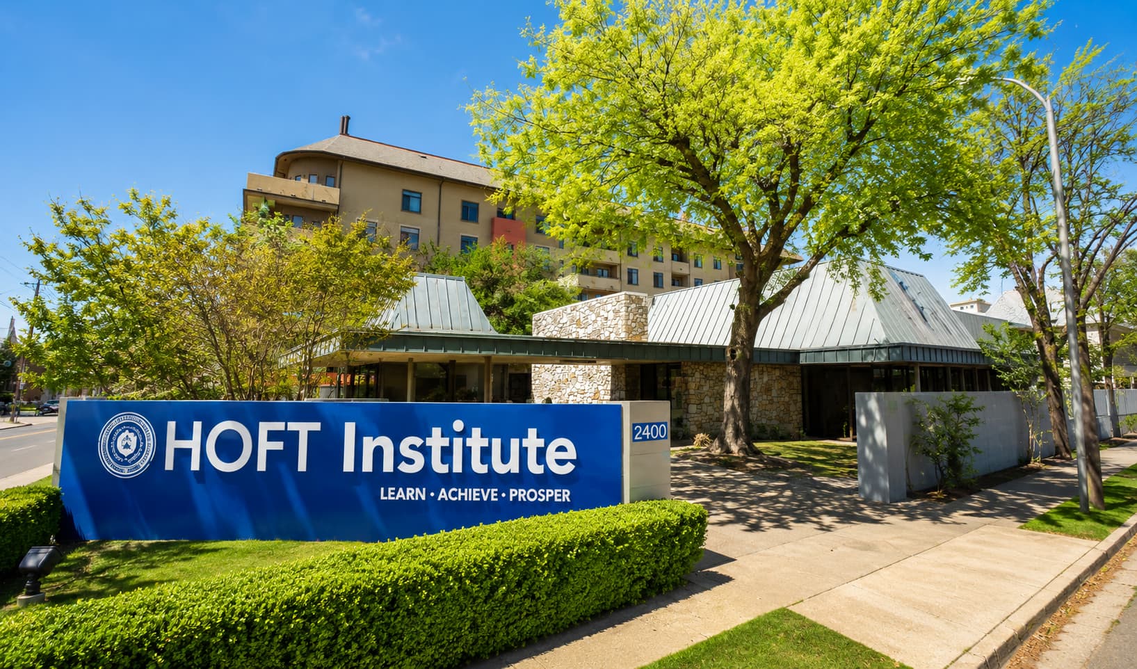 HOFT Institute があるオースティン中心部の校舎外観と青い学校サイン
