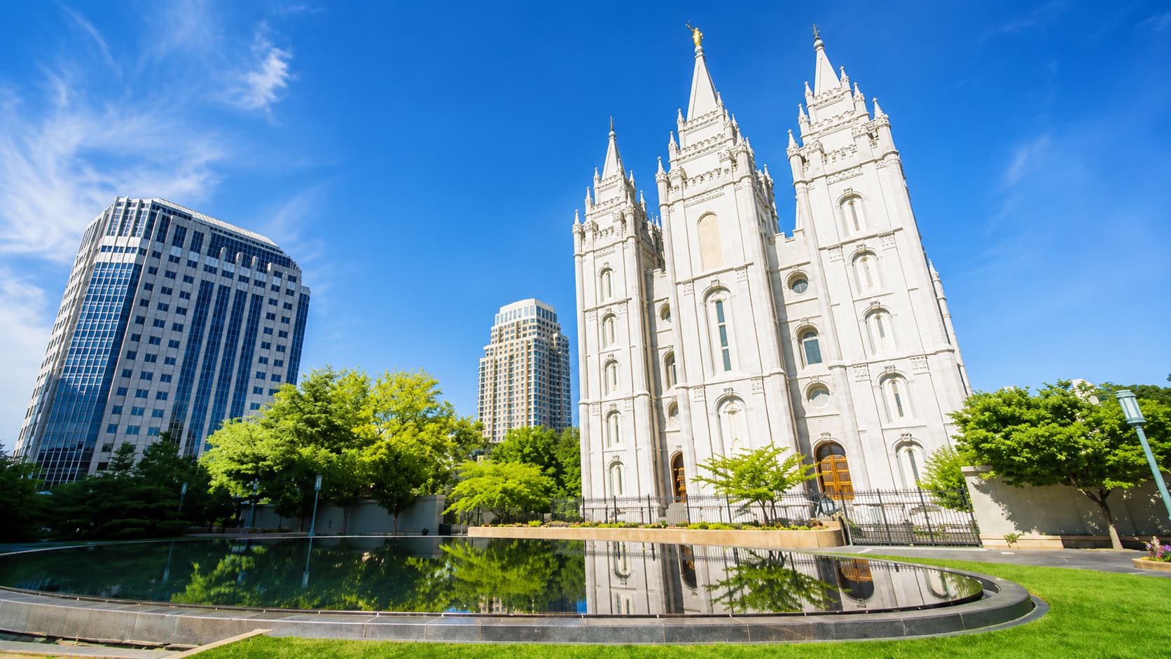 INX Academy Salt Lake City があるユタ州ソルトレイクシティ中心部の風景。歴史的なソルトレイク寺院と近代的な高層ビルが青空の下に調和する美しい街並み。。