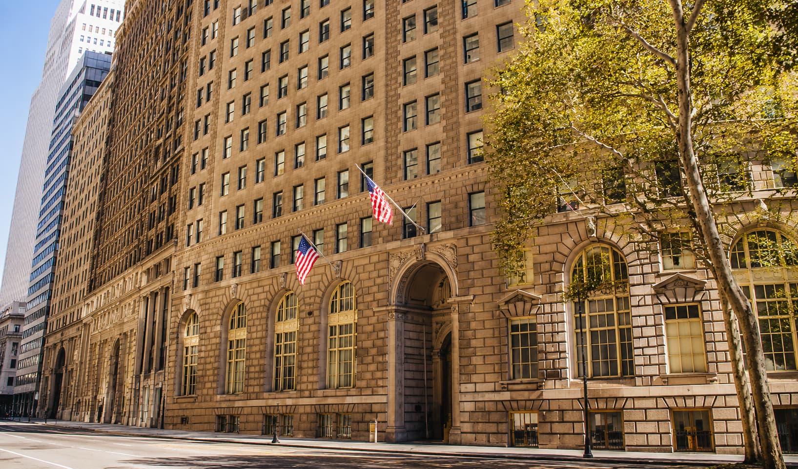 Manhattan Language が入居するニューヨーク・マンハッタン中心部の歴史あるビル外観と街路樹が彩る街並み