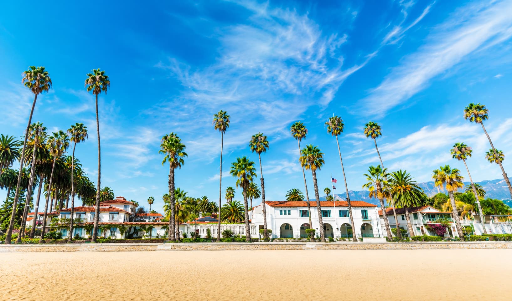 Kaplan International Languages Santa Barbara が位置する海岸沿いに広がるヤシ並木と地中海風の街並みが美しいサンタバーバラの風景